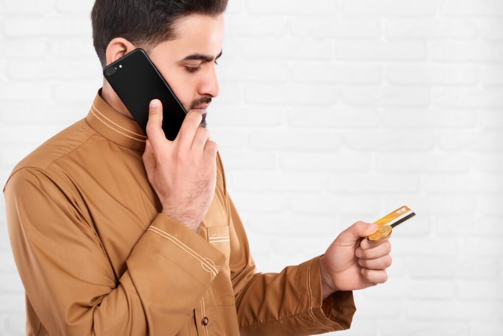 Arabian businessman keeps credit card and talks on the phone