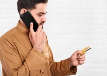 Arabian businessman keeps credit card and talks on the phone