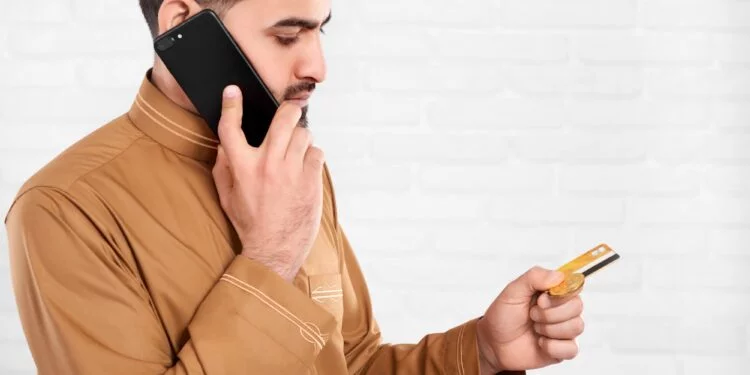 Arabian businessman keeps credit card and talks on the phone