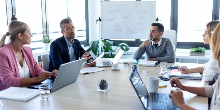 Business people discussing together in conference room during meeting at office.