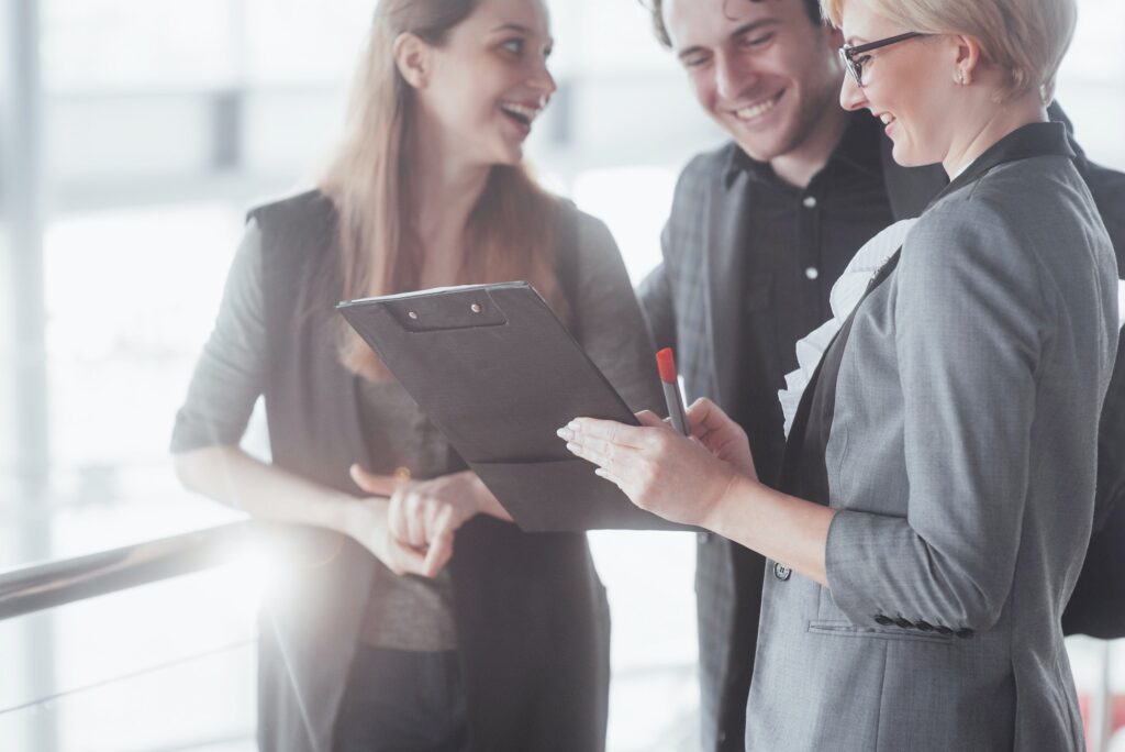 business, technology and office concept - smiling female boss talking to business team