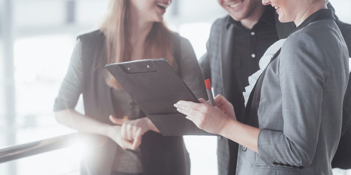 business, technology and office concept - smiling female boss talking to business team