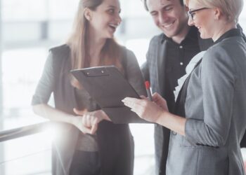 business, technology and office concept - smiling female boss talking to business team