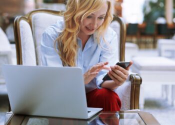 Businesswoman Using Smartphone in the Modern Bank Lobby