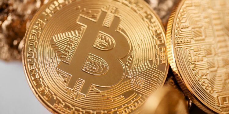 The Revolution of Blockchain Technologies in Financial Markets 1 Closeup of golden bitcoin as main cryptocurrency with gold lumps being blurred on background