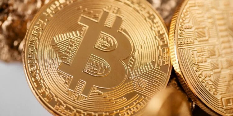 Closeup of golden bitcoin as main cryptocurrency with gold lumps being blurred on background