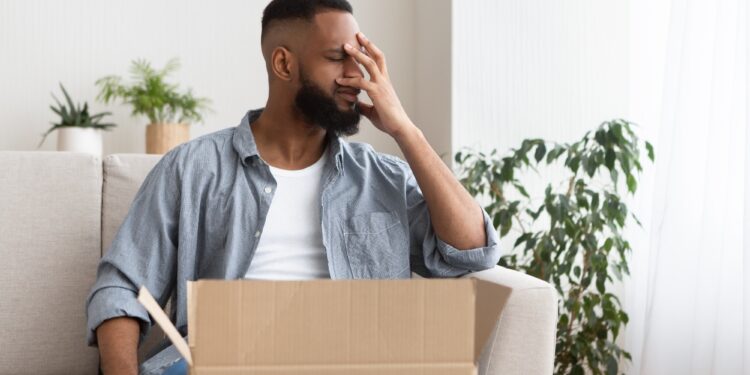 Disappointment in online shopping concept. Guy presses hand to face