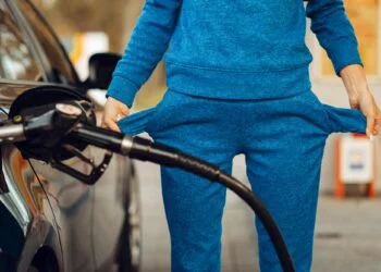 Female person with empty pockets on gas station
