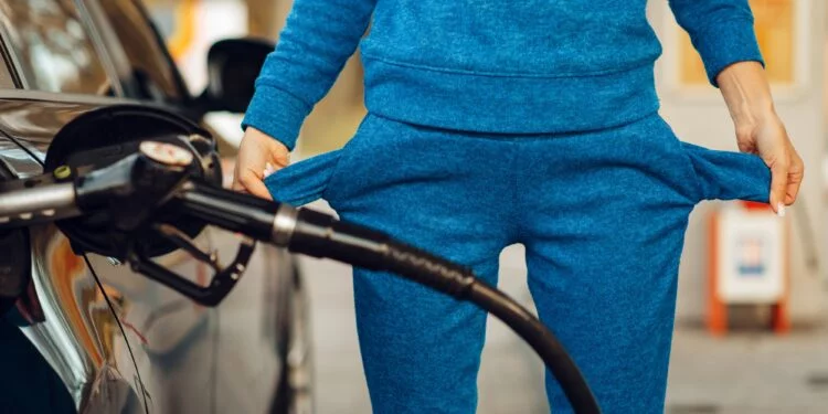 Female person with empty pockets on gas station