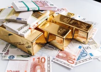 Gold bullions at euro banknotes closeup background. Gold bars lie on Euro banknotes