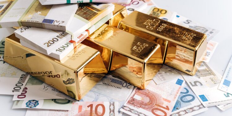 Gold bullions at euro banknotes closeup background. Gold bars lie on Euro banknotes