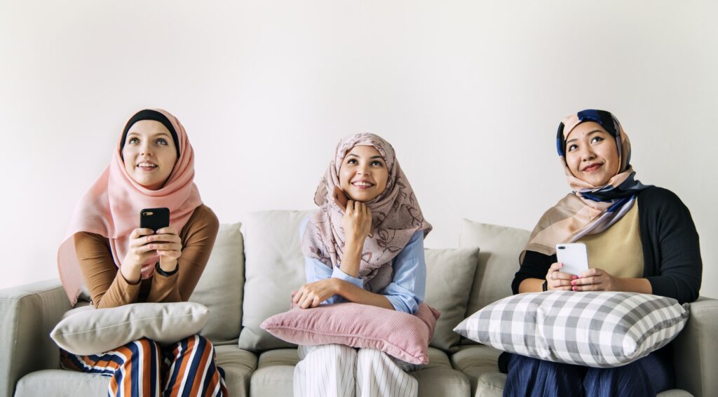 Islamic women friends using smart phone and looking up