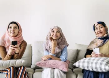 Islamic women friends using smart phone and looking up