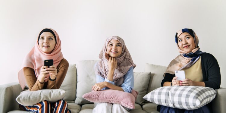 Islamic women friends using smart phone and looking up