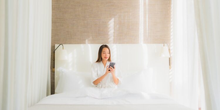 Proptech Startups: The Game Changers of Rental Housing in Southeast Asia 1 Portrait beautiful young asian woman using smart mobile phone on bed in bedroom