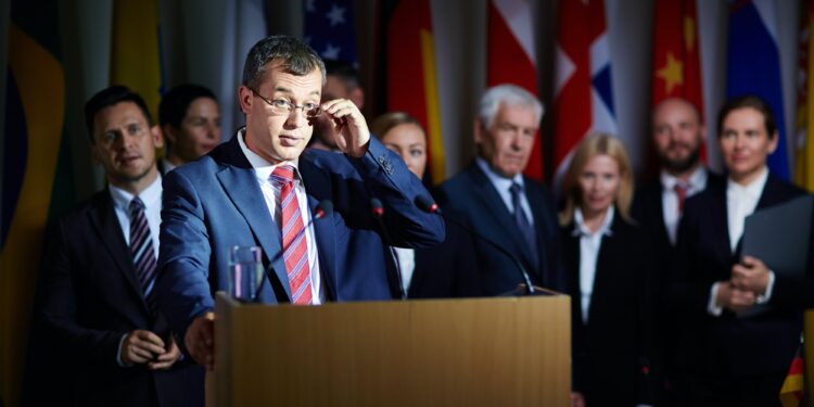 Spokesman adjusting glasses at summit