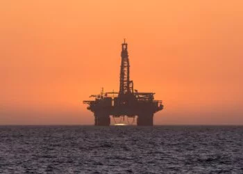 Sun setting behind oil drilling platform at Longbeach in Namibia