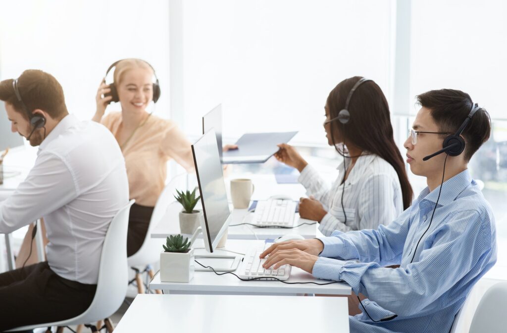 Team of technical support agents working on hotline at call center