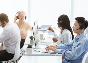 Team of technical support agents working on hotline at call center
