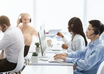 Team of technical support agents working on hotline at call center
