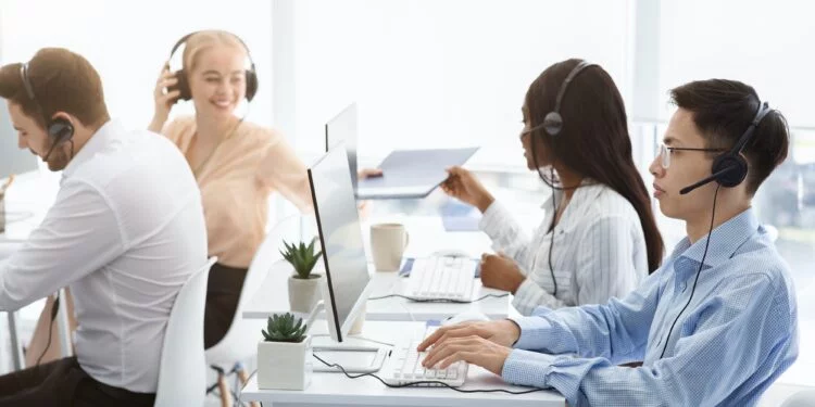 Team of technical support agents working on hotline at call center