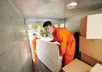 Workers loading mattress in truck