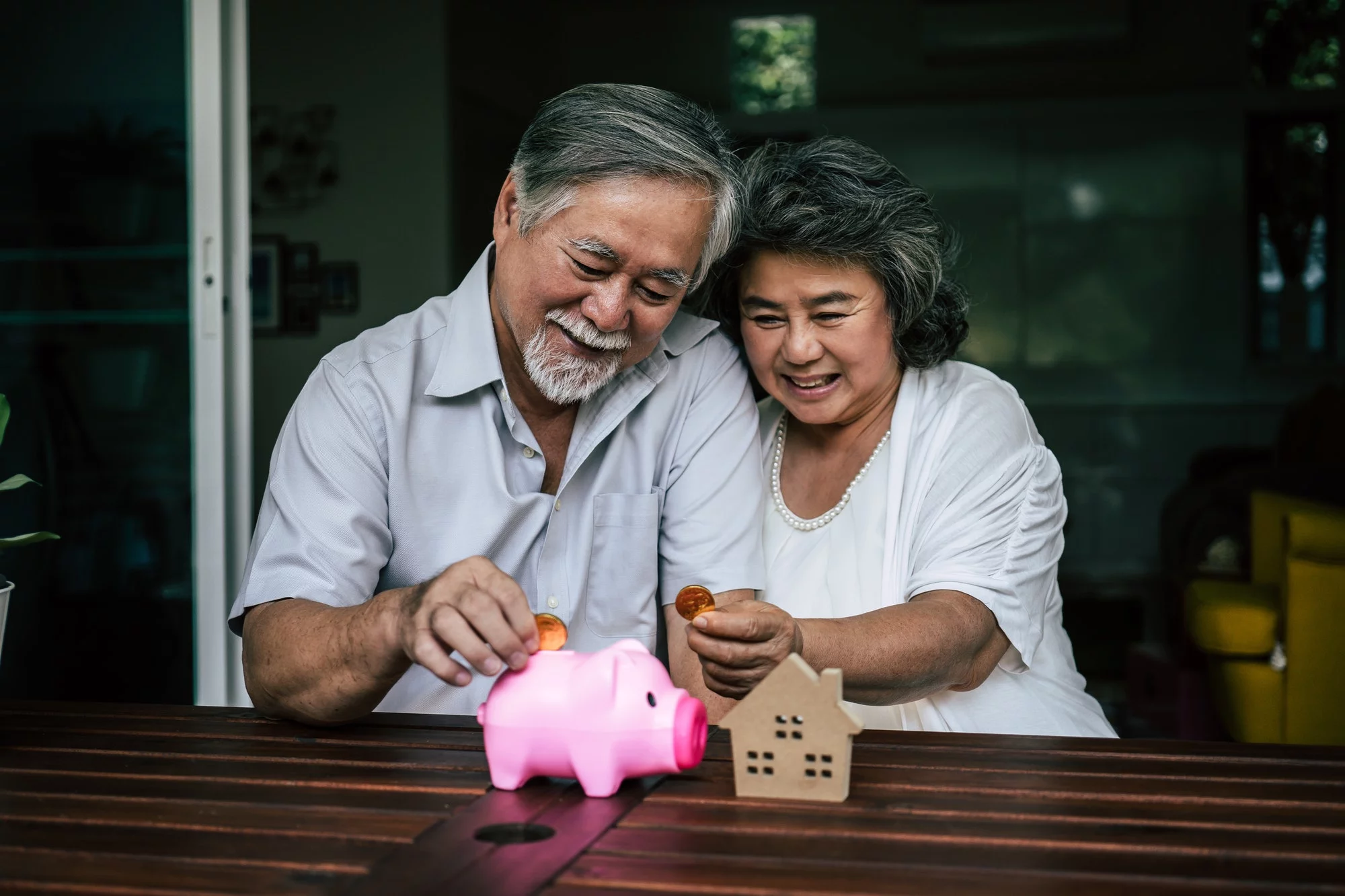 Elderly Couples talking about finance with piggy bank