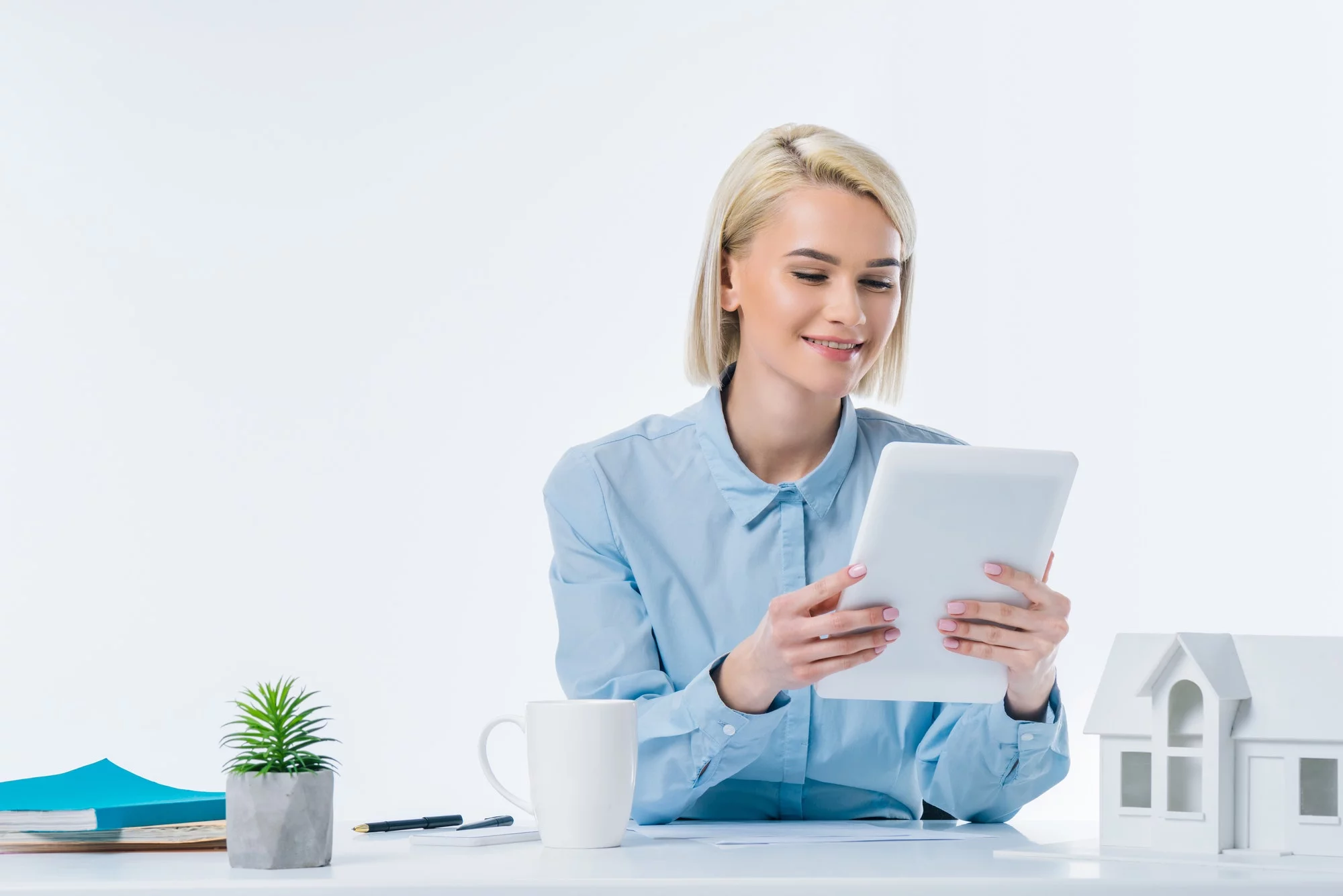 portrait of smiling real estate agent with tablet at workplace