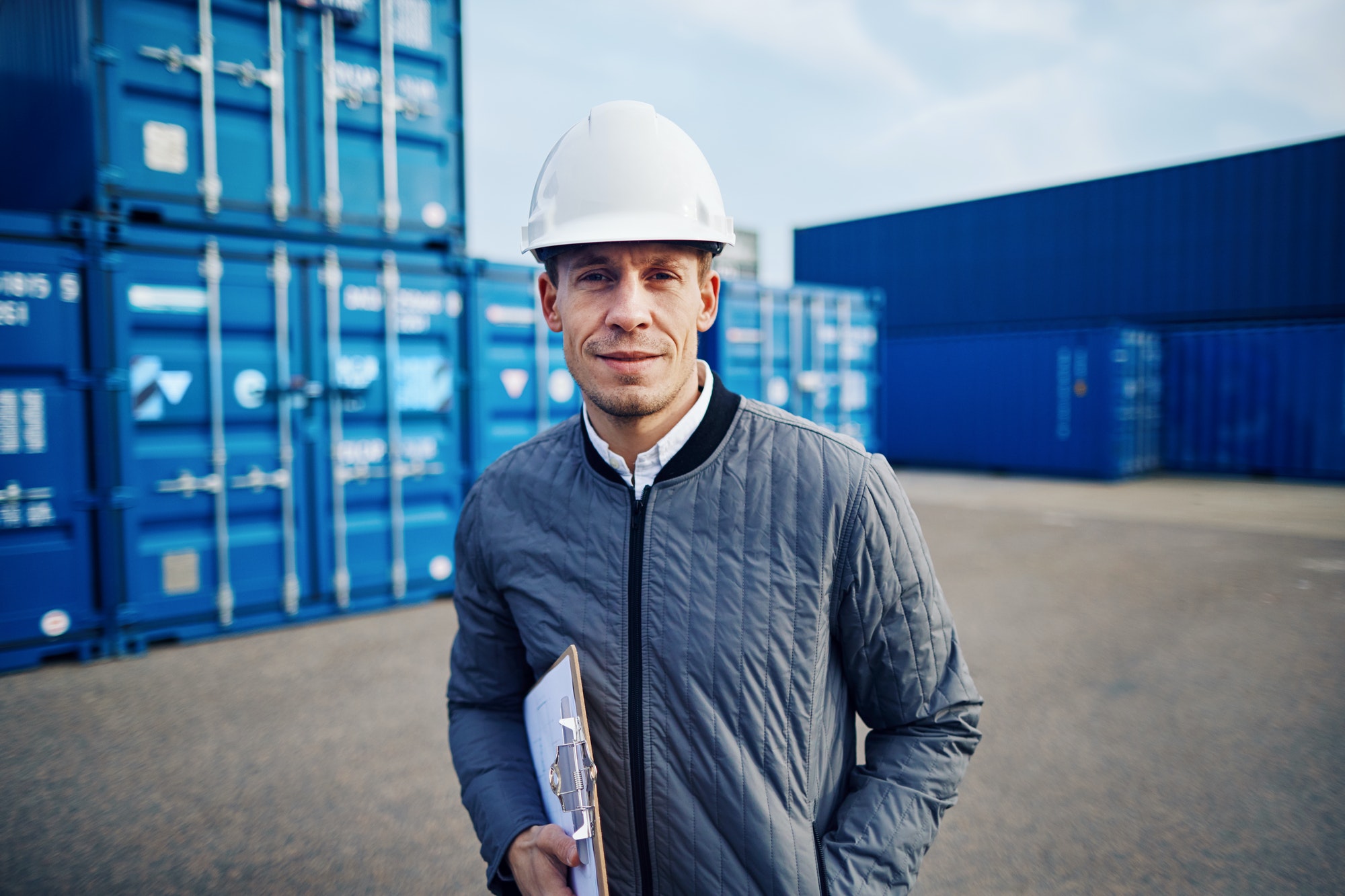 Smiling dock foreman standing in a commercial shipping yard