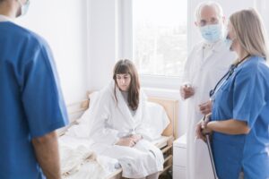 Doctors in masks and a patient with suspected coronavirus in a hospital