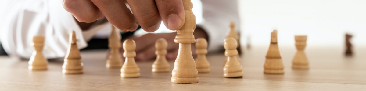 Business leader arranging chess pieces with king in the leading position