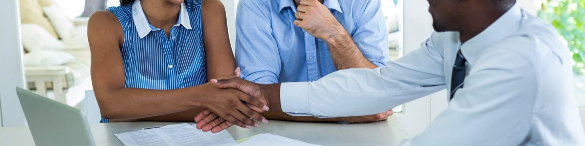 Happy couple shaking hands with real estate agent