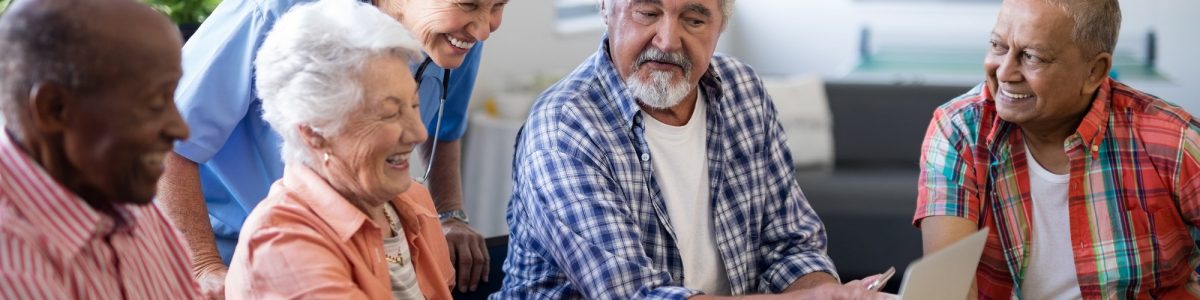 Senior people showing laptop to healthcare worker